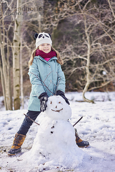 Porträt eines lächelnden Mädchens mit Schneemann