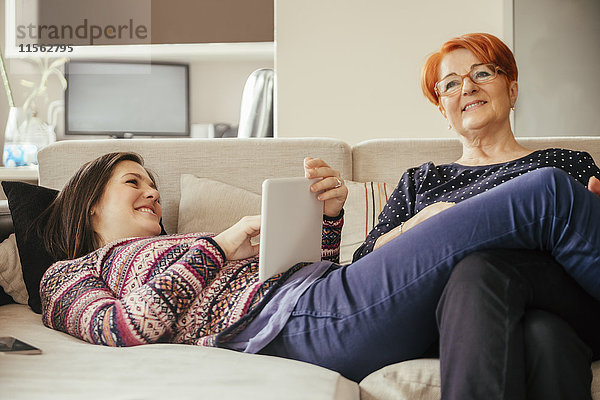 Erwachsene Tochter mit Mutter zu Hause mit Tablette