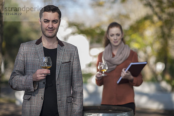 Mann und Frau mit Gläsern Wein im Freien