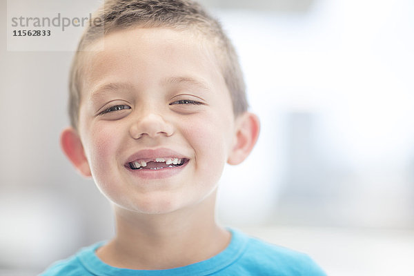 Porträt eines lachenden Jungen mit Zahnlücke