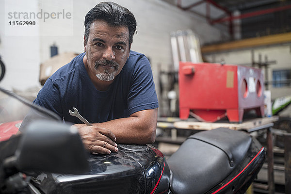 Porträt eines selbstbewussten Mechanikers in der Motorradwerkstatt