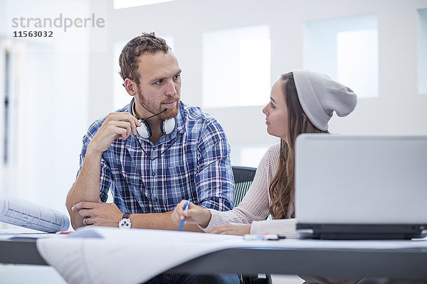 Junger Mann und Frau diskutieren Projekt im Designbüro