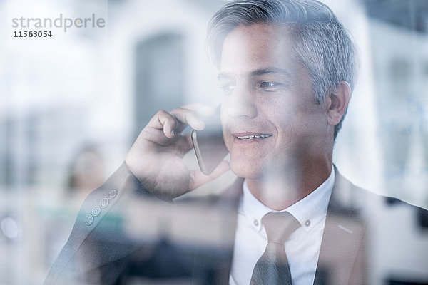 Geschäftsmann im Büro beim Telefonieren