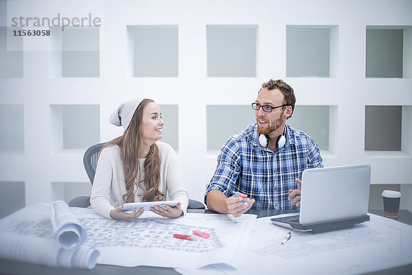 Junger Mann und Frau diskutieren Projekt im Designbüro