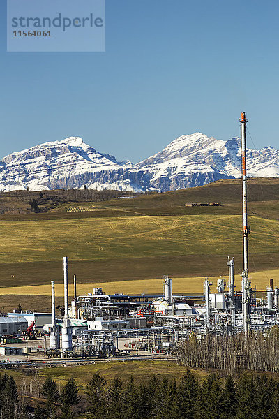 Gaswerk im Vorgebirge mit schneebedeckter Bergkette und blauem Himmel; Alberta  Kanada'.