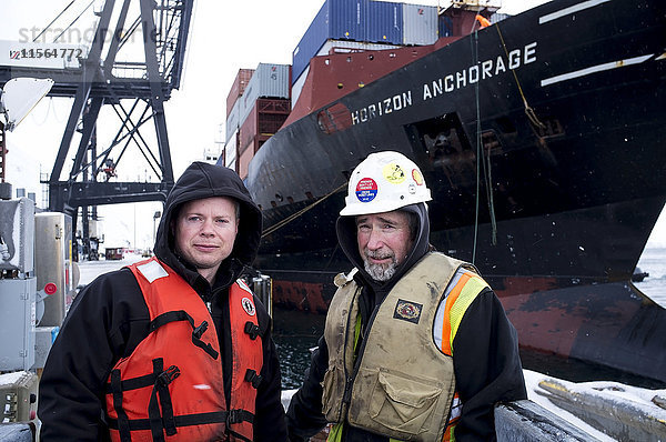 Hafenarbeiter beim Festmachen des Schiffes Horizon Lines Anchorage am Dock des Unalaska Marine Center in Unalaska  Südwest-Alaska  Alaska