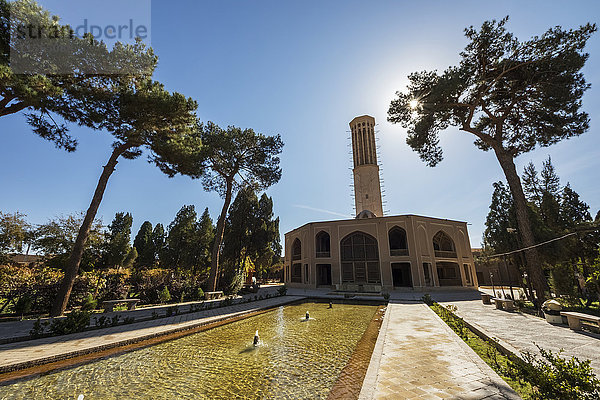 Teich entlang der zentralen Achse mit dem Sommerpavillon und einem hohen Windturm (Badgir) im Hintergrund  Dolat Abad Garten; Yazd  Iran'.