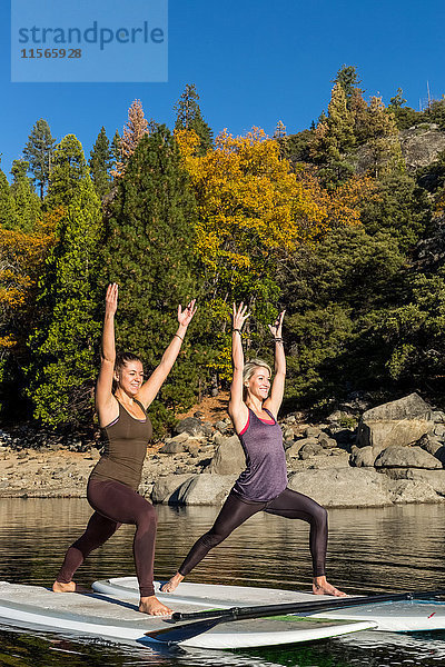 Fitness-Modelle beim Yoga auf einem Paddleboard auf dem Pinecrest Lake; Kalifornien  Vereinigte Staaten von Amerika'.