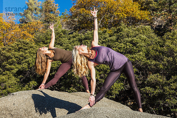 Fitness-Modelle beim Yoga auf einem Felsen  Pinecrest Lake; Kalifornien  Vereinigte Staaten von Amerika'.