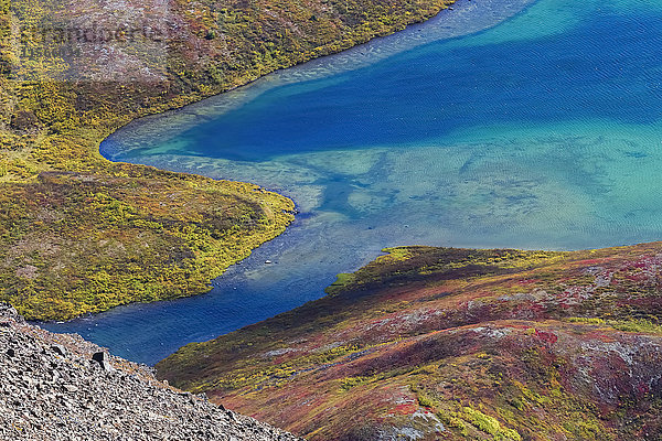 Leuchtende Herbstfarben umgeben den Landmark Gap Lake in den Amphitheater Mountains  nur wenige Kilometer vom Denali Highway entfernt; Alaska  Vereinigte Staaten von Amerika'.