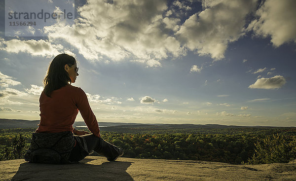 Frau sitzt auf einer Klippe mit Blick auf den Algonquin Park; Ontario  Kanada'.