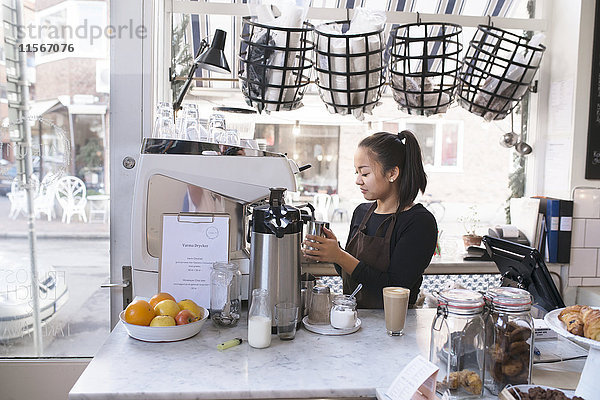 Frau bereitet Kaffee in einem Café zu
