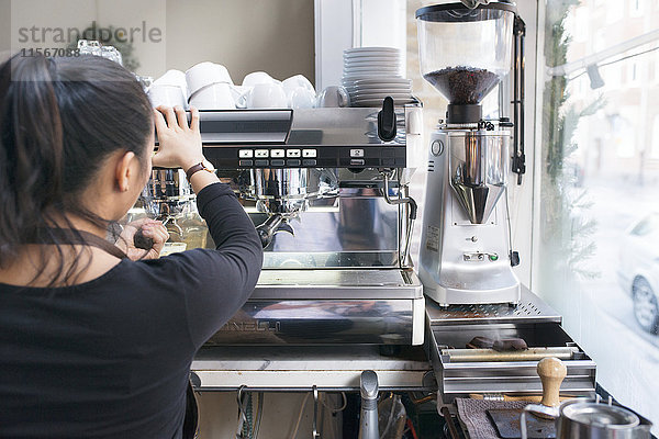 Frau bereitet Kaffee in einem Café zu
