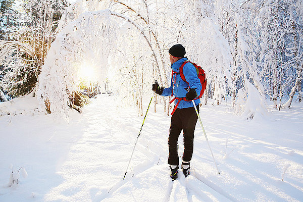 Mann beim Skifahren in einem malerischen Wald