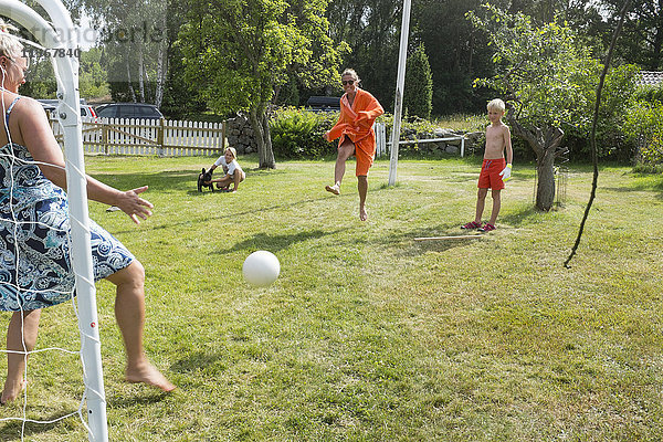 Familie spielt Fußball im Garten