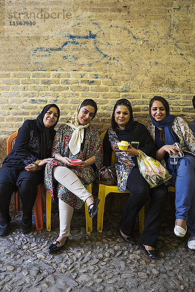 Junge Frauen genießen das gefrorene Dessert Fallodeh auf dem Vakil-Basar; Shiraz  Provinz Fars  Iran'.