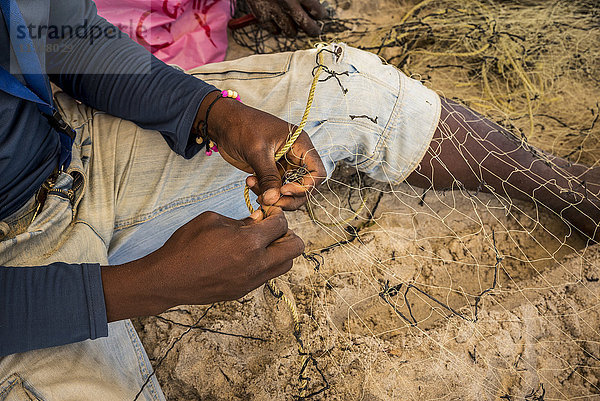 Einheimischer Fischer bei der Reparatur von Fischernetzen; Pemba  Cabo Delgado  Mosambik'.