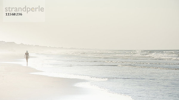 USA  North Carolina  Frau geht am leeren Strand spazieren