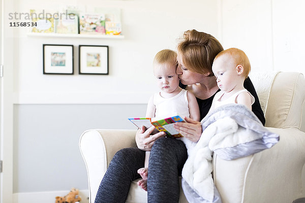 Mutter und Söhne (12-17 Monate) lesen Bilderbuch