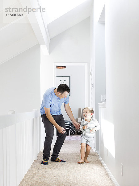 Vater und Sohn (4-5) spielen im Korridor