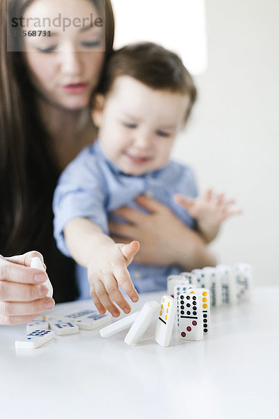 Mutter spielt Dominospiel mit Sohn (4-5)