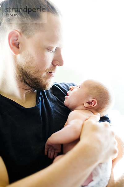 Porträt eines Mannes  der seinen neugeborenen Sohn (0-1 Monate) im Arm hält