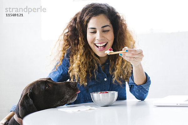 Frau mit Hund isst Snack