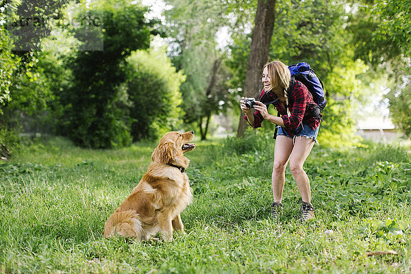 Frau fotografiert Hund auf Wandertour