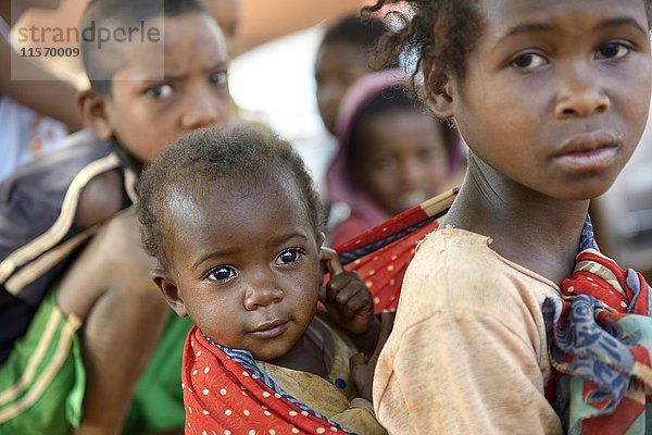 Mädchen trägt Schwester auf dem Rücken  Dorf Analakely  Gemeinde Tanambao  Madagaskar  Afrika