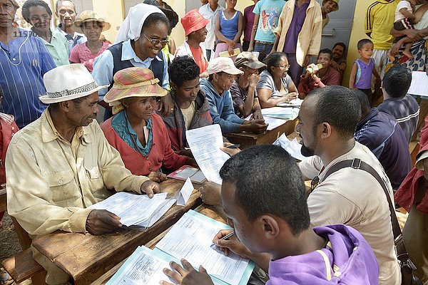 Dorfbewohner füllen auf dem Dorfplatz Anträge auf Zertifizierung ihres Landes aus  Dorf Analakely  Gemeinde Tanambao  Bezirk Tsiroanomandidy  Region Bongolava  Madagaskar  Afrika