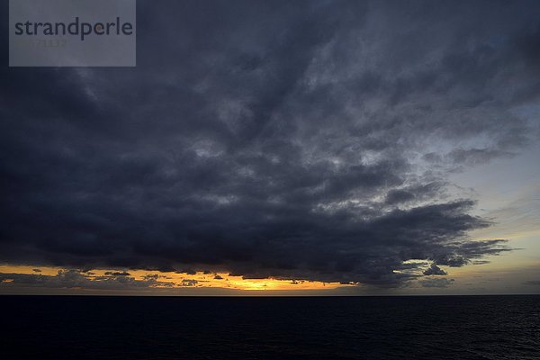 Sonnenuntergang mit Regenwolken auf dem offenen Meer  Atlantik