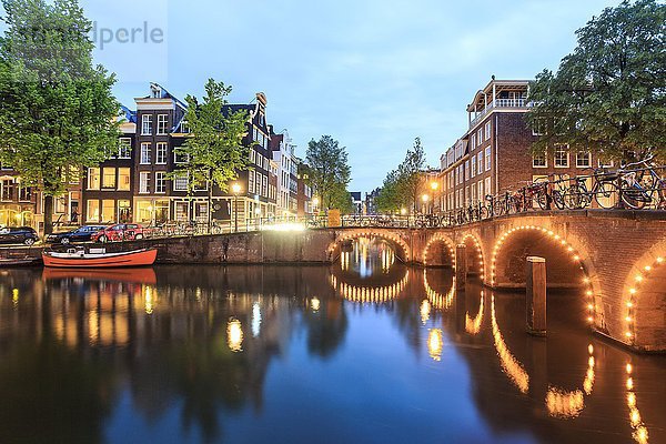 Fahrräder  Boote  Grachten und charmante Architektur in der Abenddämmerung  Amsterdam  Niederlande