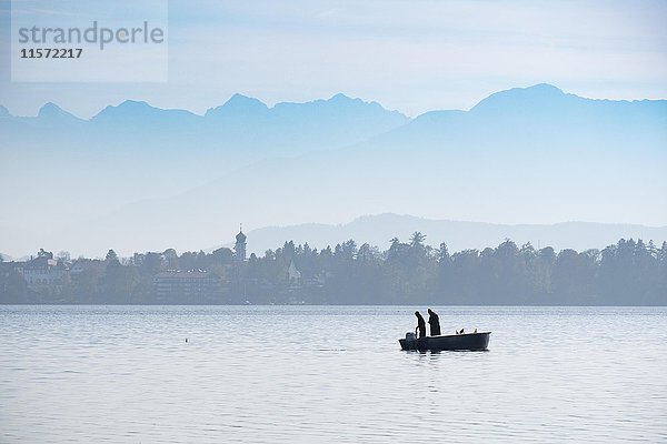 Fischer im Boot  Starnberger See mit Alpen  Seeshaupt  Fünfseenland  Oberbayern  Bayern  Deutschland  Europa