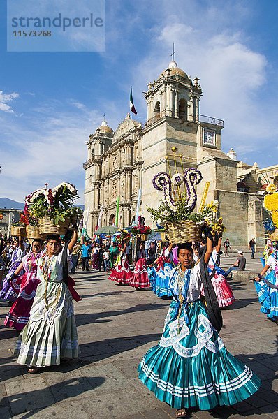 Frauen in traditionellen Kleidern mit Blumenkörben tanzen auf dem Hauptplatz Zocalo vor der Kirche Santo Domingo de Guzman  Zentrum  Oaxaca  Mexiko  Mittelamerika