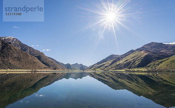 Sonnenstern  Berge spiegeln sich im See  Moke Lake bei Queenstown  Region Otago  Südland  Neuseeland  Ozeanien