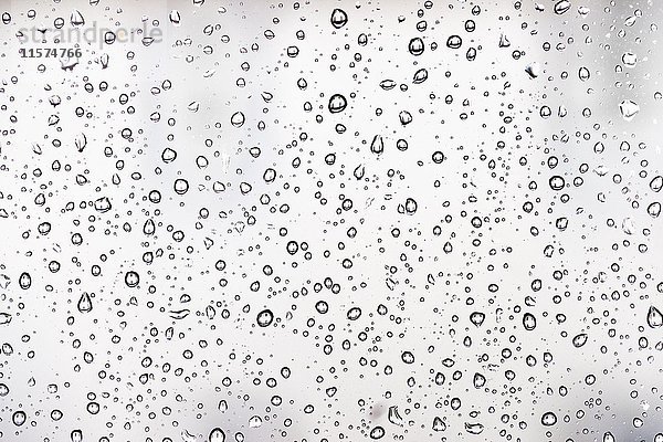 Wassertropfen auf einer Fensterscheibe  Glasscheibe  Fenster  Regen  schlechtes Wetter  Vollbild  Hintergrundbild