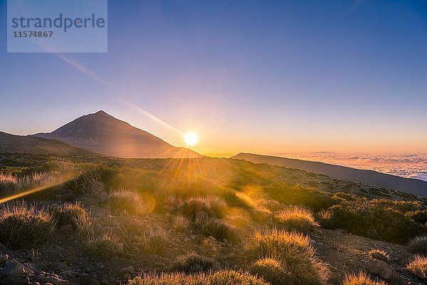 Sonnenuntergang  Sonnenuntergangsglühen  bewölkter Himmel  Vulkan Teide und Vulkanlandschaft  beleuchtete Landschaft  Nationalpark El Teide  Teneriffa  Kanarische Inseln  Spanien  Europa
