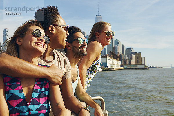 Vier erwachsene Freunde  die von der Uferpromenade des Flusses hinausblicken  New York  USA