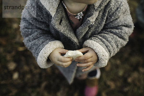 Kleines Mädchen hält ein Stück Brot
