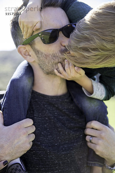 Junge beugt sich vor  um Vater zu küssen