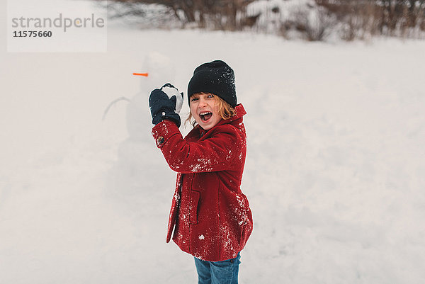 Mädchen macht sich bereit  Schneeball zu werfen