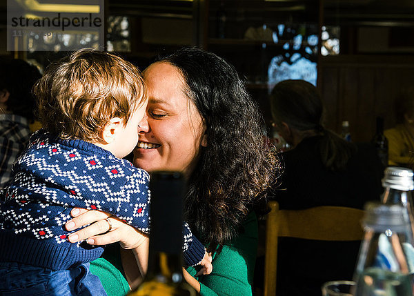 Reife Frau von Angesicht zu Angesicht mit ihrem kleinen Sohn im Café