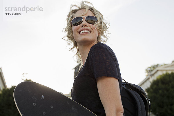 Skateboarderin mit Skateboard im Park