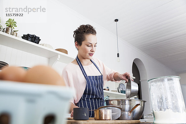 Junge Frau bereitet sich auf das Backen an der Küchentheke vor