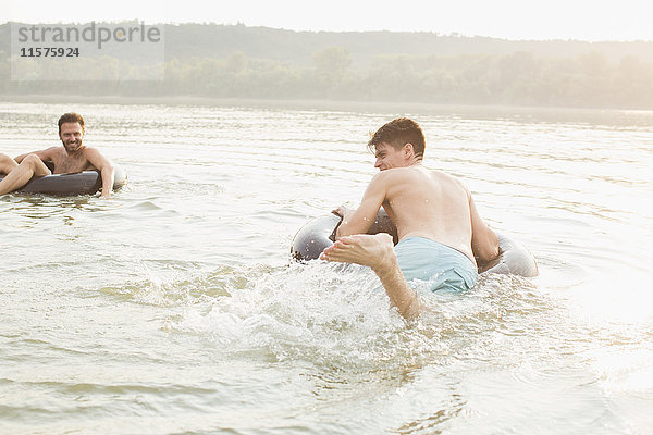 Freunde haben Spaß mit aufblasbarem Ring im Fluss