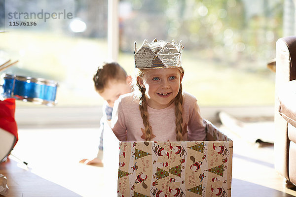 Mädchen sitzt zu Weihnachten in einem Karton