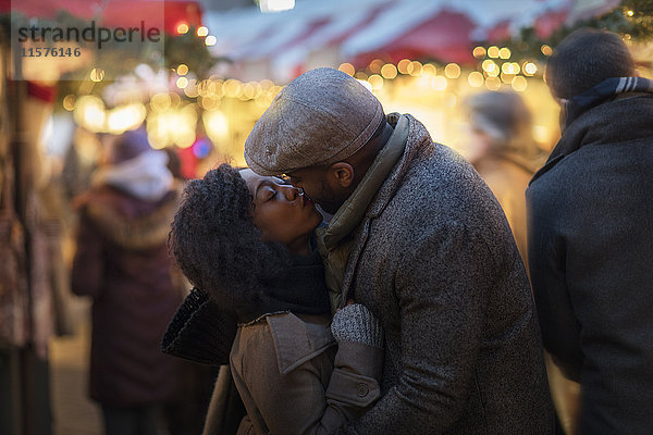 Romantisches Paar küsst sich auf dem Weihnachtsmarkt  New York  USA