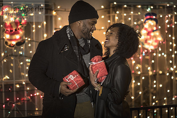 Romantisches Paar tauscht nachts Weihnachtsgeschenke aus  New York  USA