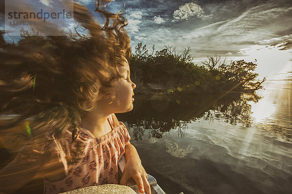 Junges Mädchen genießt eine Flussfahrt  die Augen geschlossen und sich im Sonnenlicht sonnt  Homosassa  Florida  USA