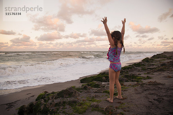 Mädchen am Strand  die Arme erhoben und in die Ferne blickend  Blowing Rocks Preserve  Jupiter  Florida  USA